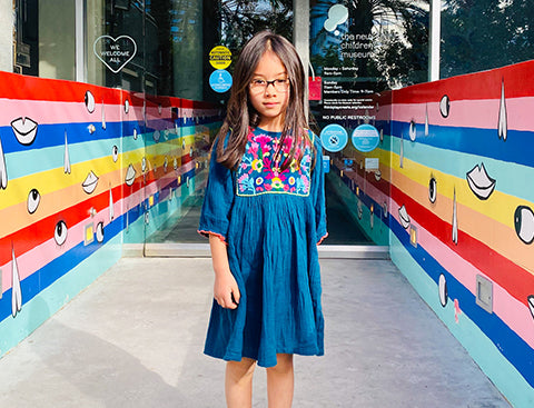Luna, our latest Flock Star, stand in front of colorful museum entrance wearing her Arianna Dress. Click to read the full interview with Luna!